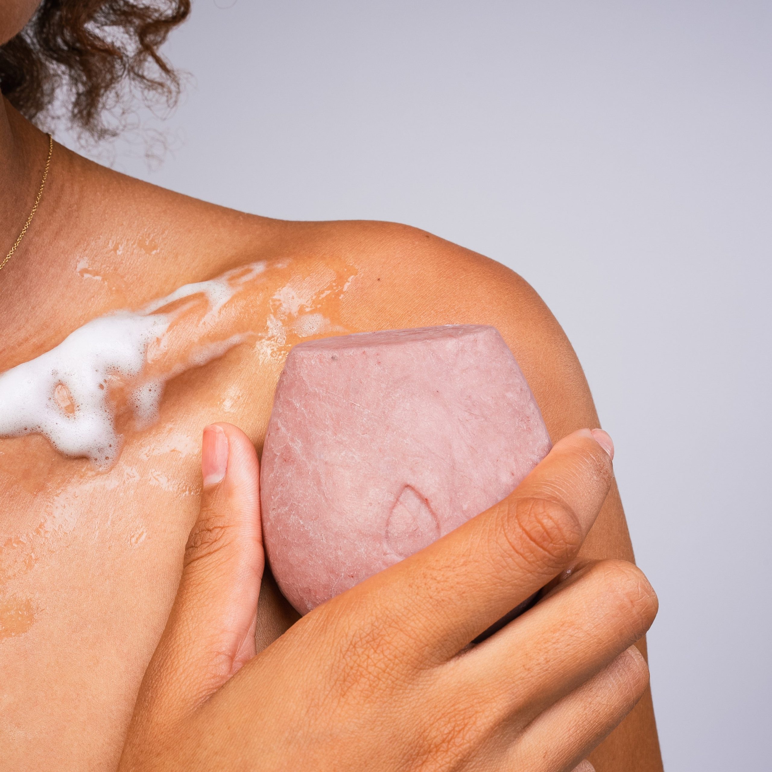 BodyWash_Nourish_Modelholdingbar_nopackaging_tobody_suds.jpg
